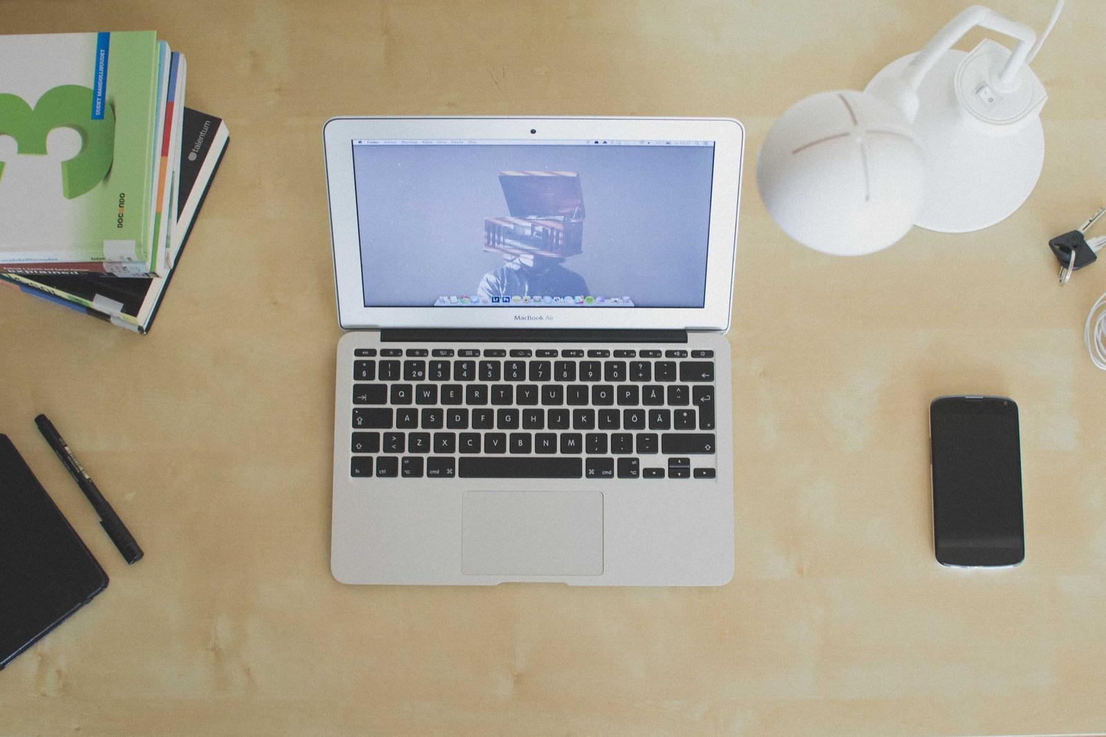 A laptop open on a clean desk beside a phone
