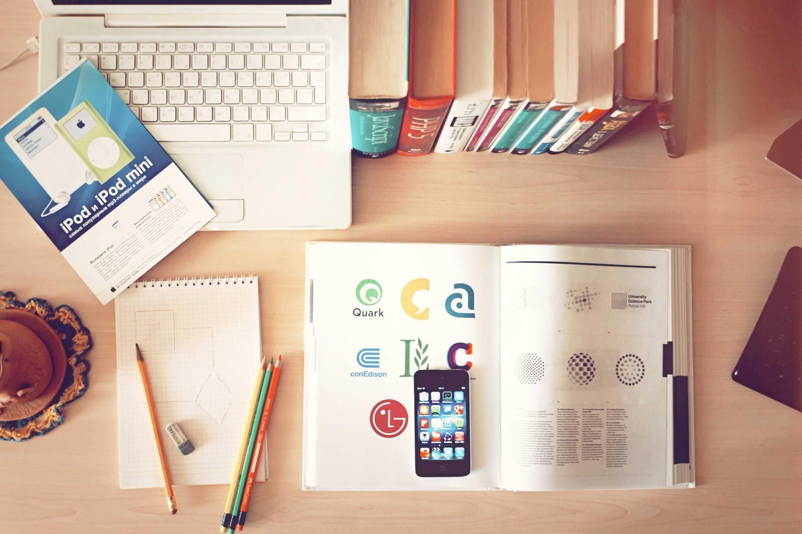 Notes, a phone and printed design material spread on a desk